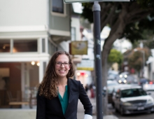 woman stands on street near sign